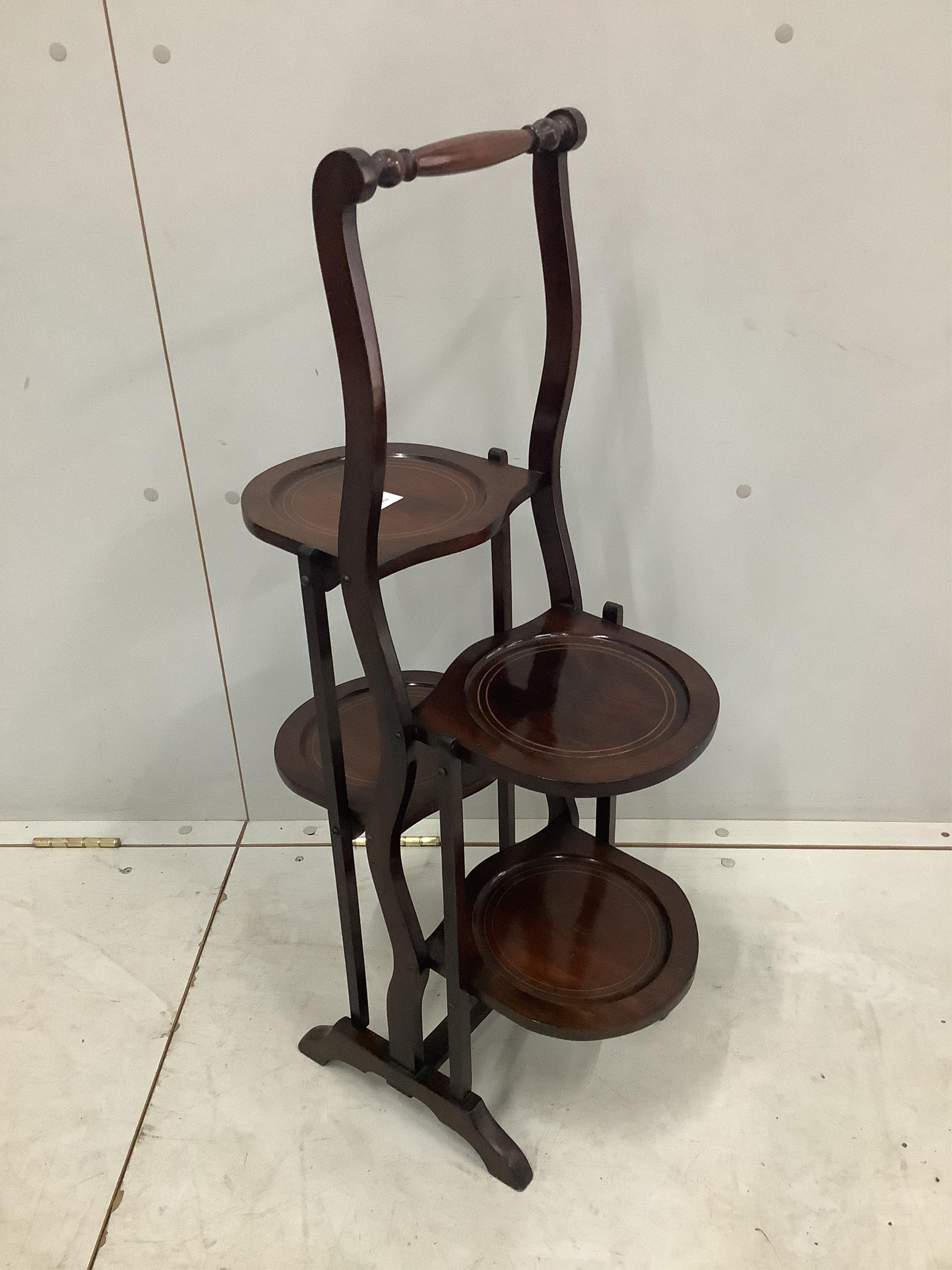 An Edwardian inlaid mahogany four dish folding cake stand, height 86cm. Condition - good